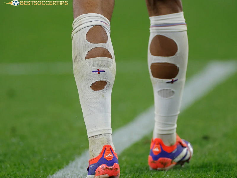 Why do football players cut holes in their socks?